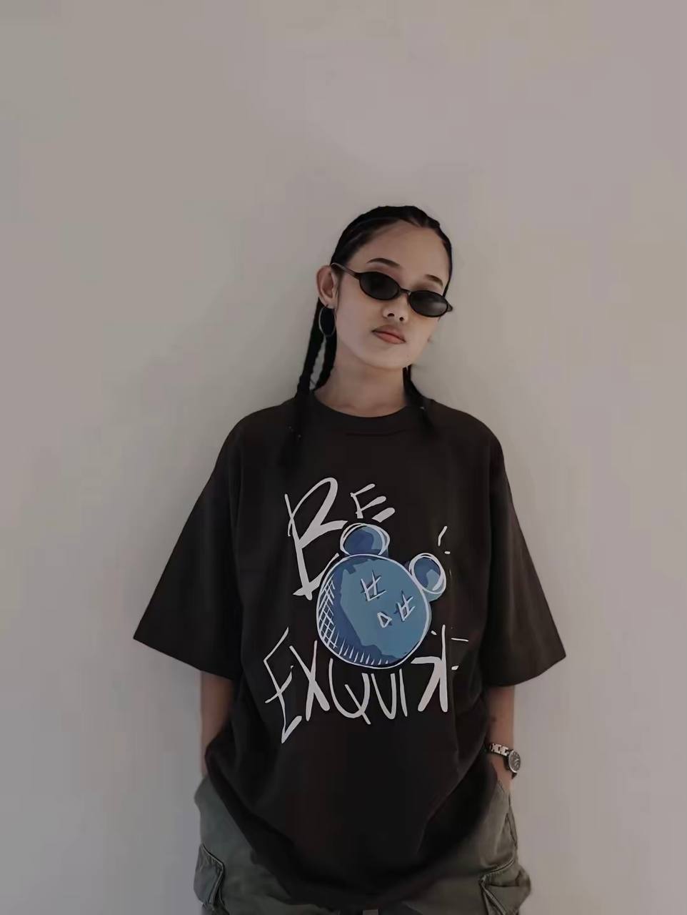 Person wearing a black t-shirt with a graphic design against a plain background