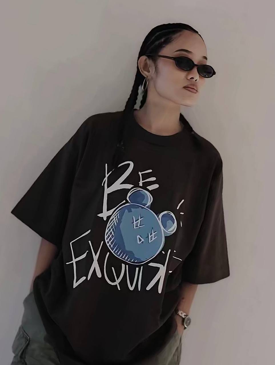 Person wearing a black t-shirt with a graphic design and text, standing against a plain background.